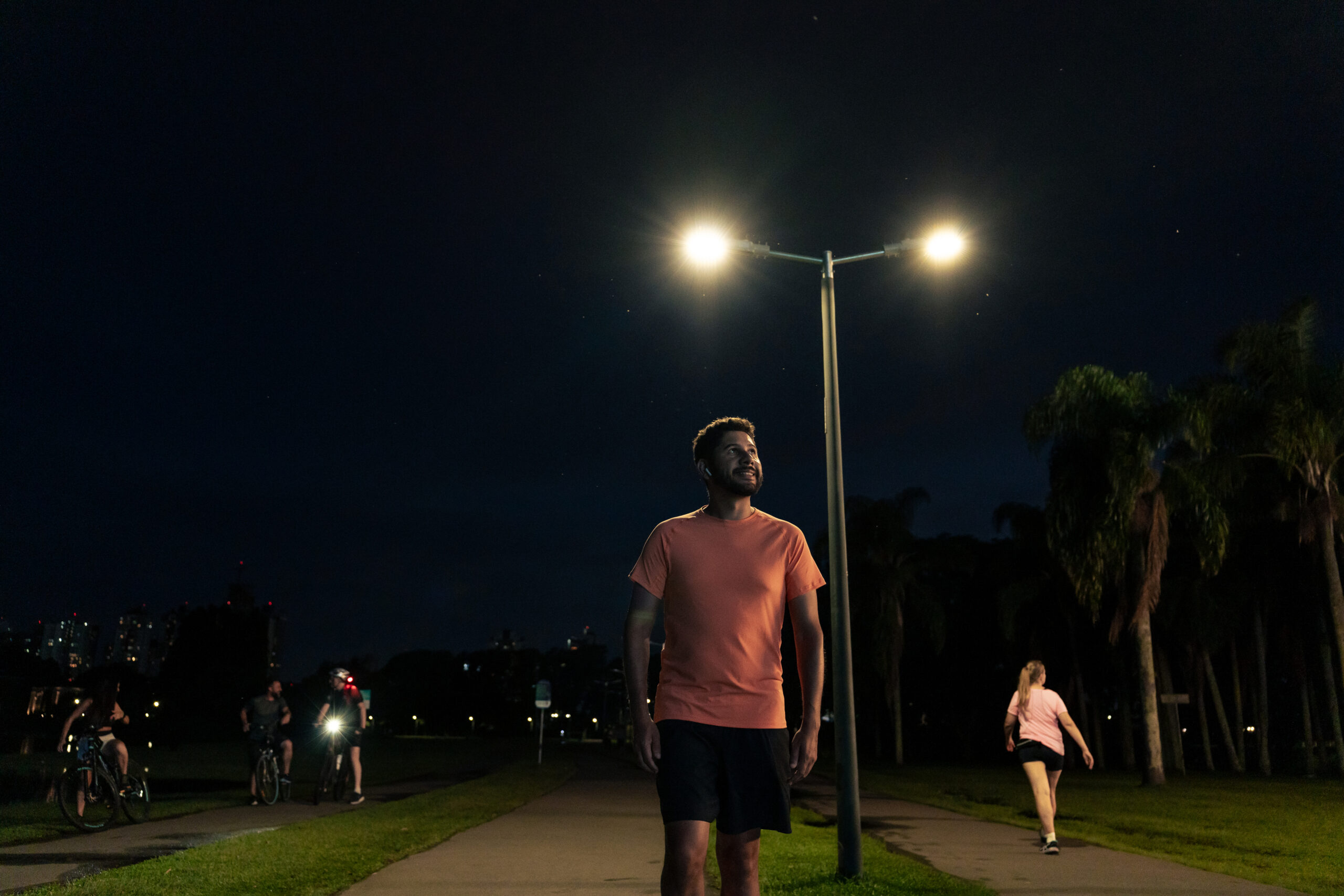 Latino man running at night in the park (Smart Lighting Controls)