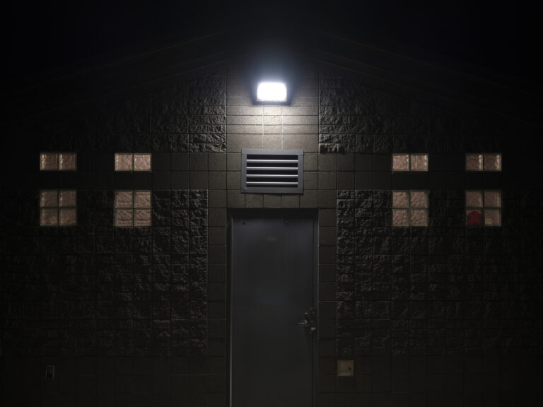 Floodlight illuminating outside of a structure at night on a cold winter day in a park