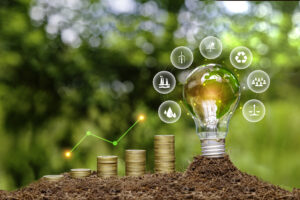 Green tree growing on pile of gold coins. light bulb on green nature background green energy icon around it. Investing in the environment, society, governance. ESG Investing in the industrial.